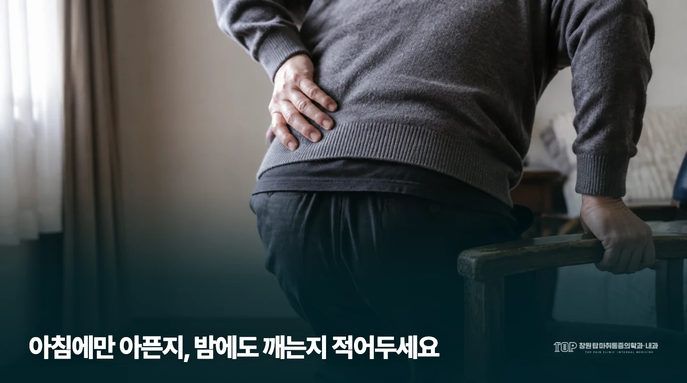 의자 팔걸이를 잡고 허리 불편을 살피는 생활 장면