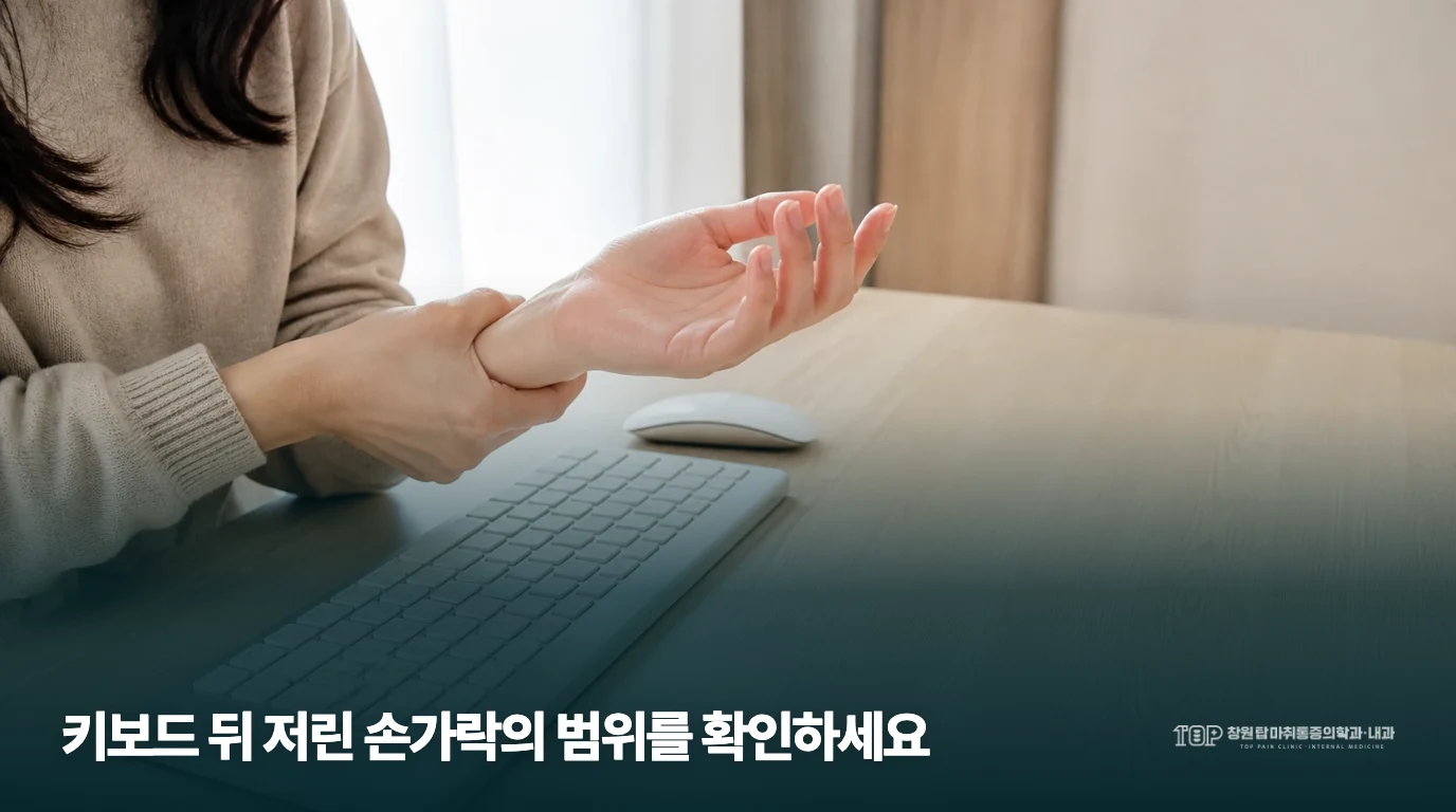 키보드 앞에서 손목 주변의 불편을 표현하는 근접 장면