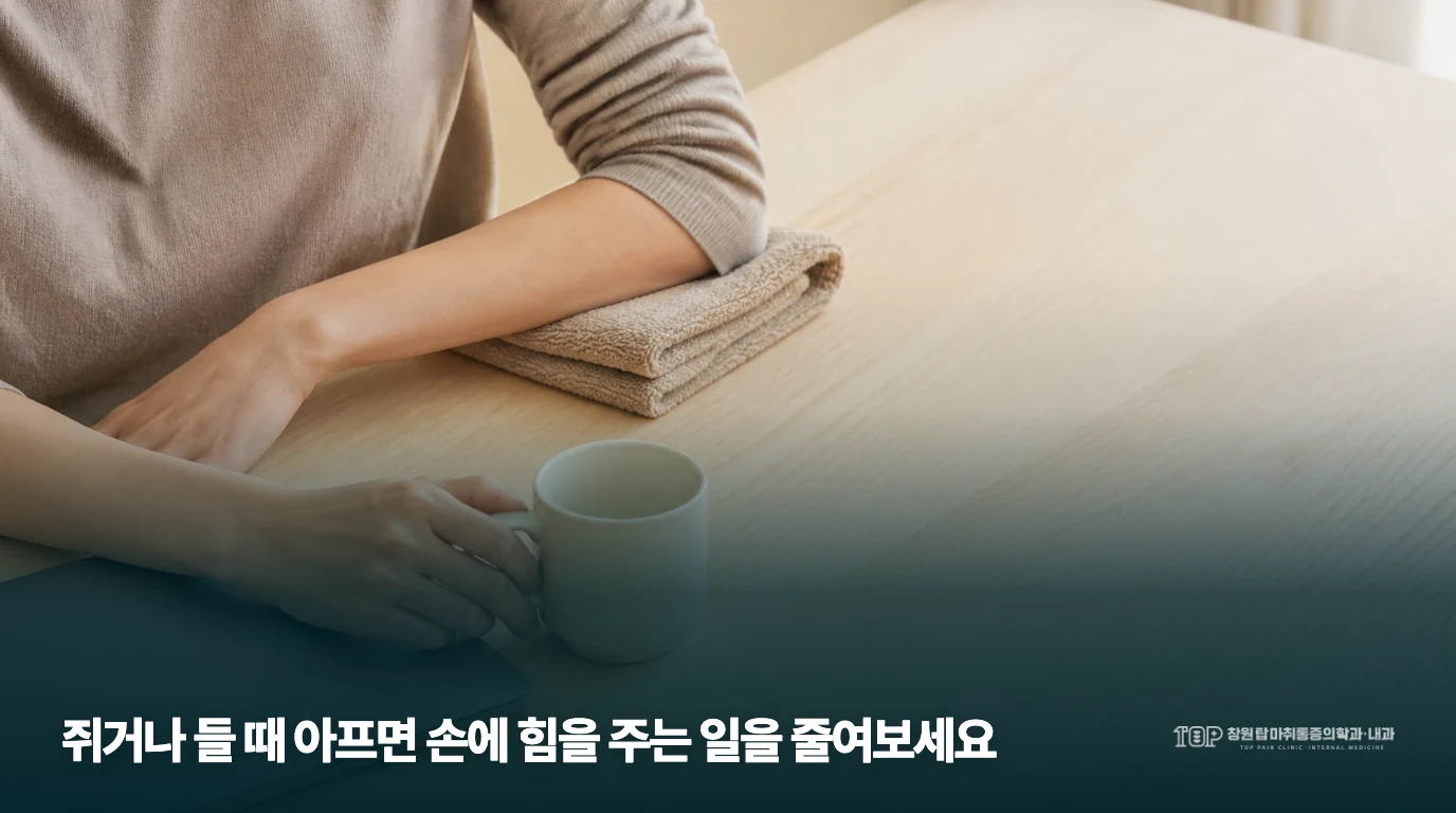 한쪽 팔을 수건 위에 두고 다른 손으로 컵 손잡이를 잡은 모습