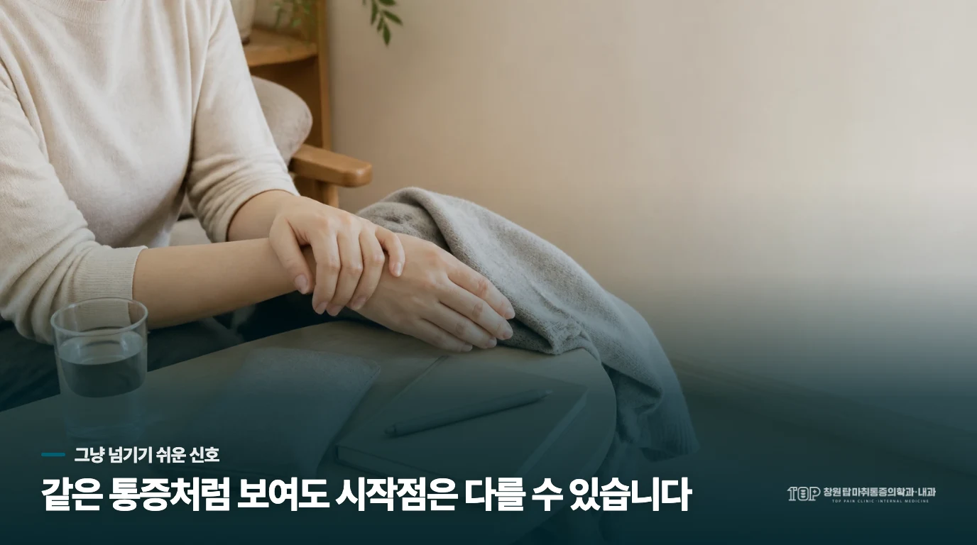 식탁에서 손가락 마디 주변을 다른 손으로 살펴보는 모습